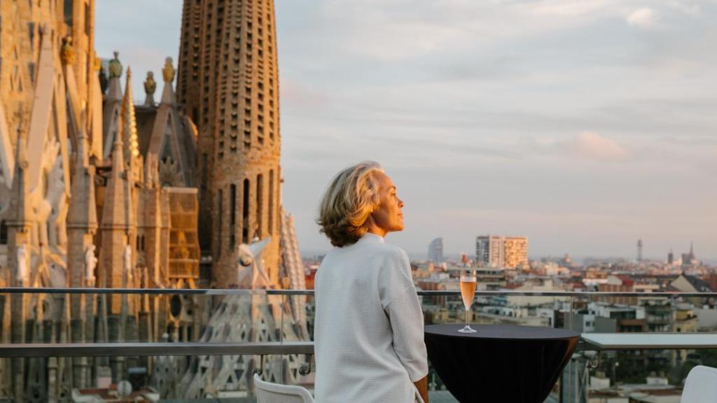 Una mujer en una terraza junto a la Sagrada Família de Barcelona