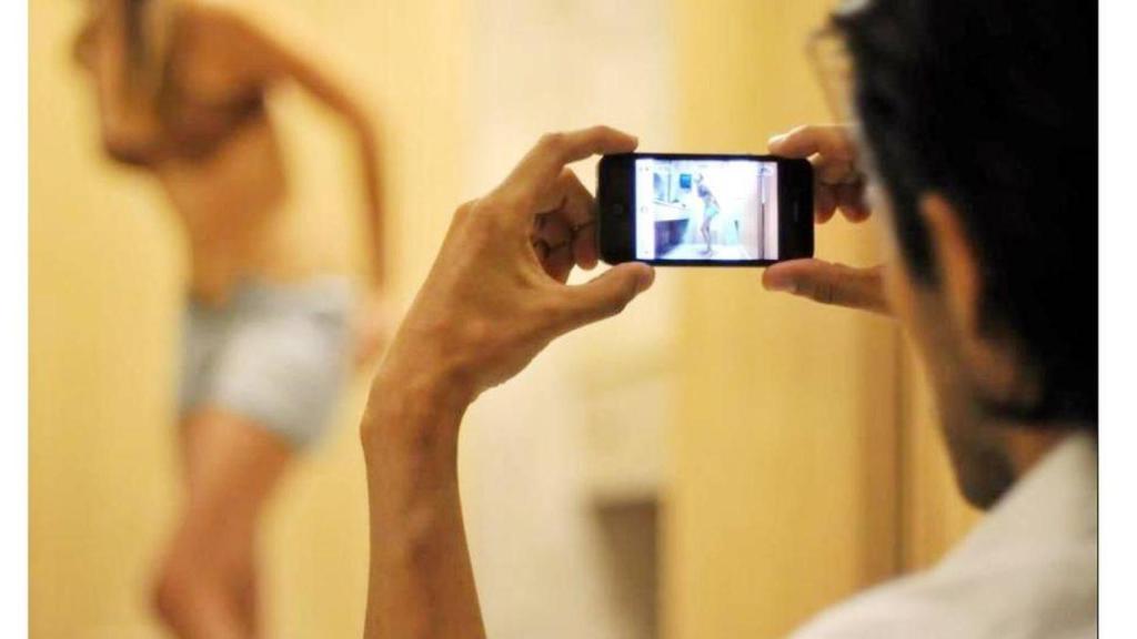 Imagen de archivo de un hombre grabando a una mujer