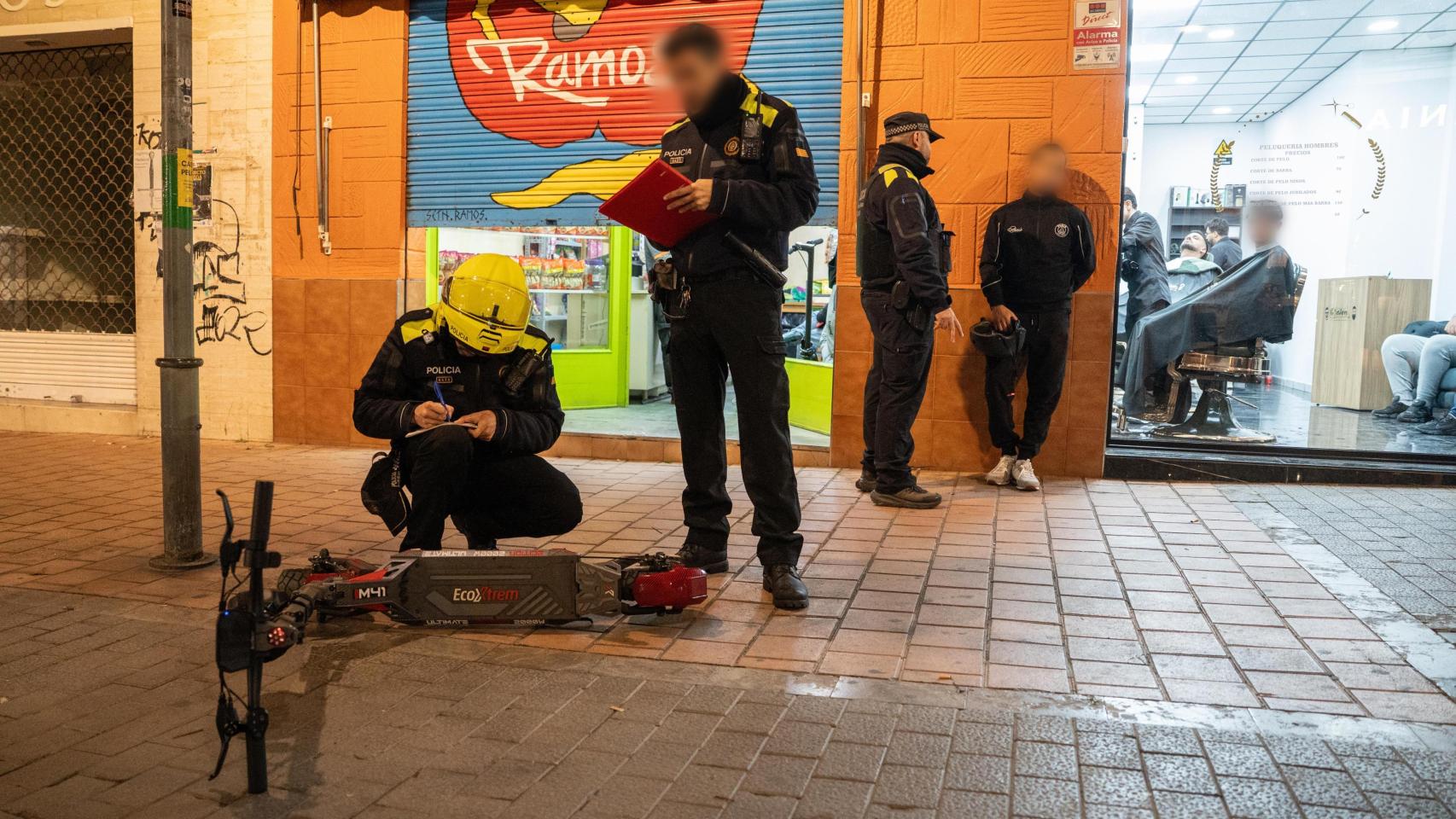Agentes de la Guardia Urbana de Badalona revisando un patinete