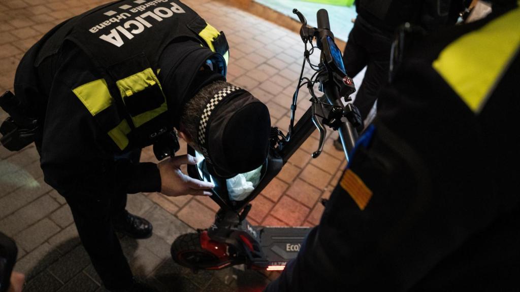 Agentes de la Guardia Urbana de Badalona revisando un patinete