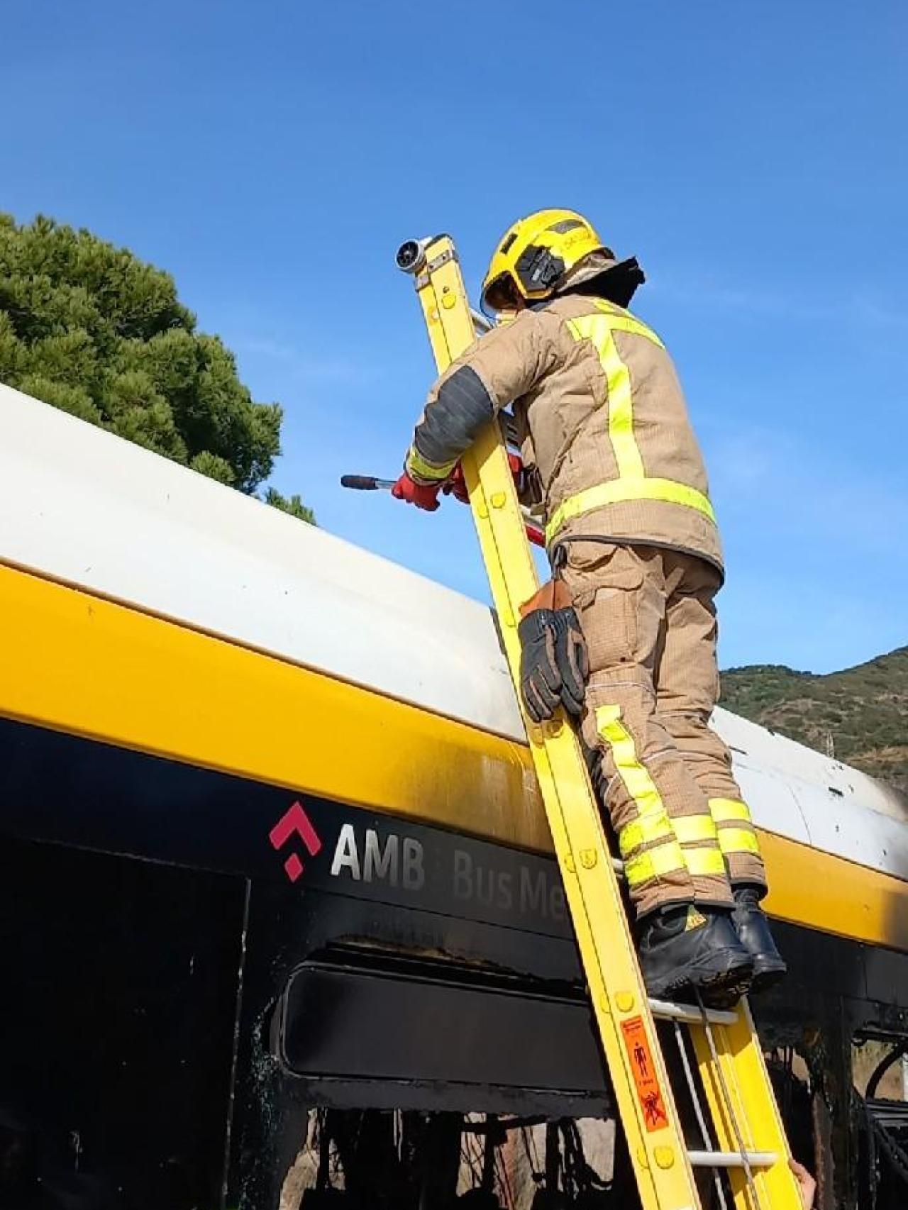 Un bombero revisa las baterías del autobús del AMB que ha ardido este sábado