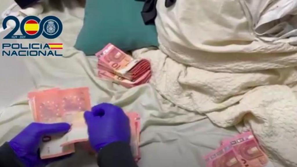 Agente contando el dinero acumulado en uno de los pisos francos