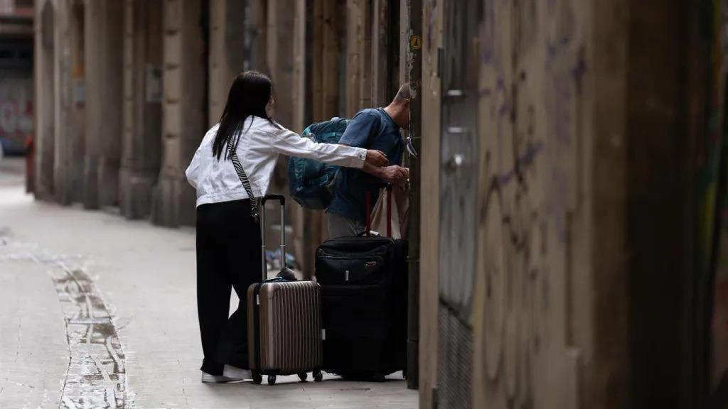 Visitantes acceden a una vivienda turística en Barcelona