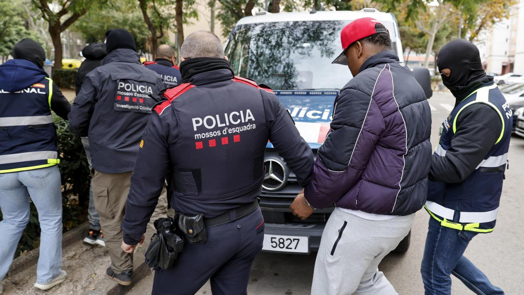Agentes de los Mossos d'Esquadra y de la Policía Nacional custodian a varios de los detenidos
