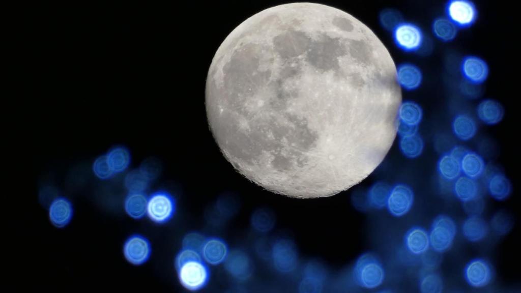 Luna llena fotografiada en Gavà con las luces de Navidad