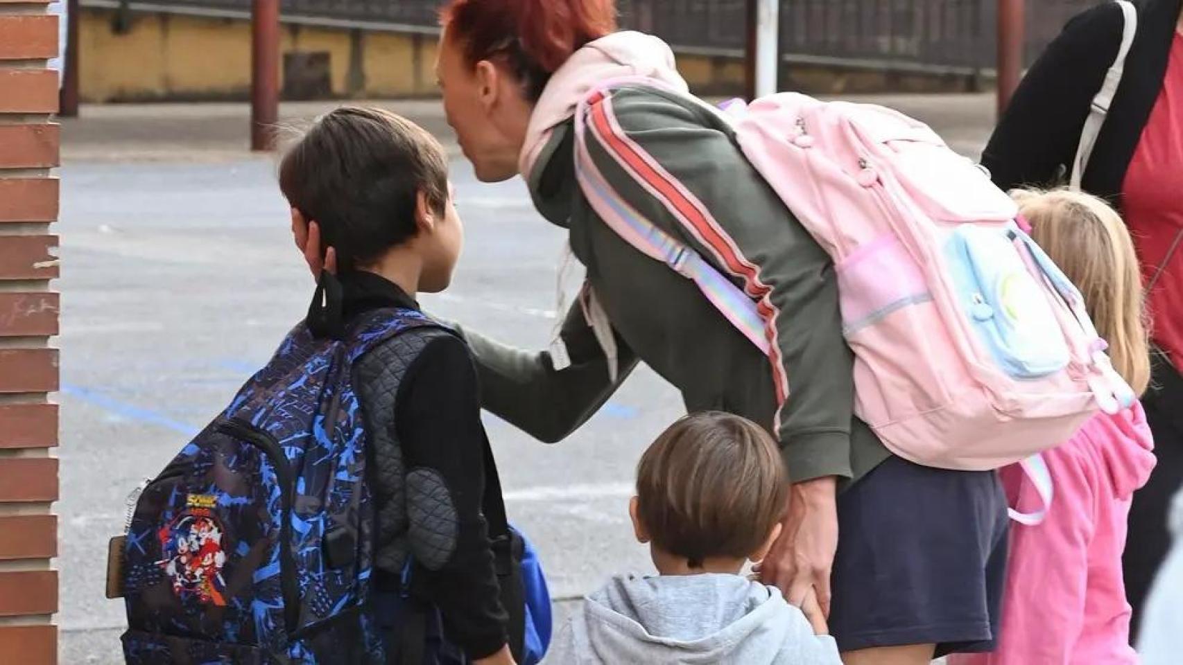 Una madre con sus hijos en la entrada de un colegio