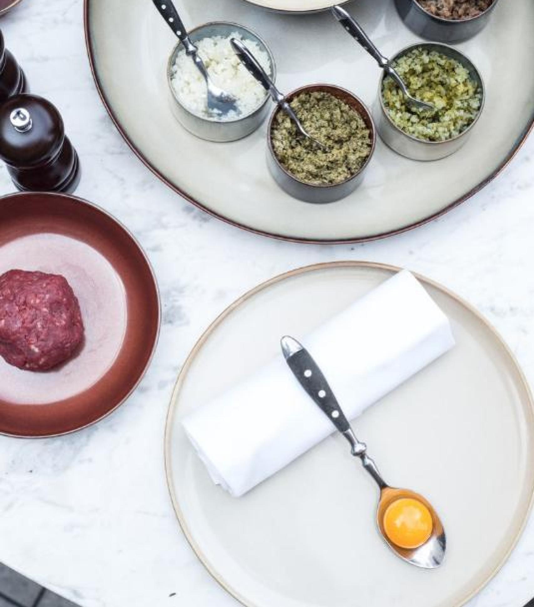 Preparación del steak tartar, uno de los platos estrella, delante de los comensales