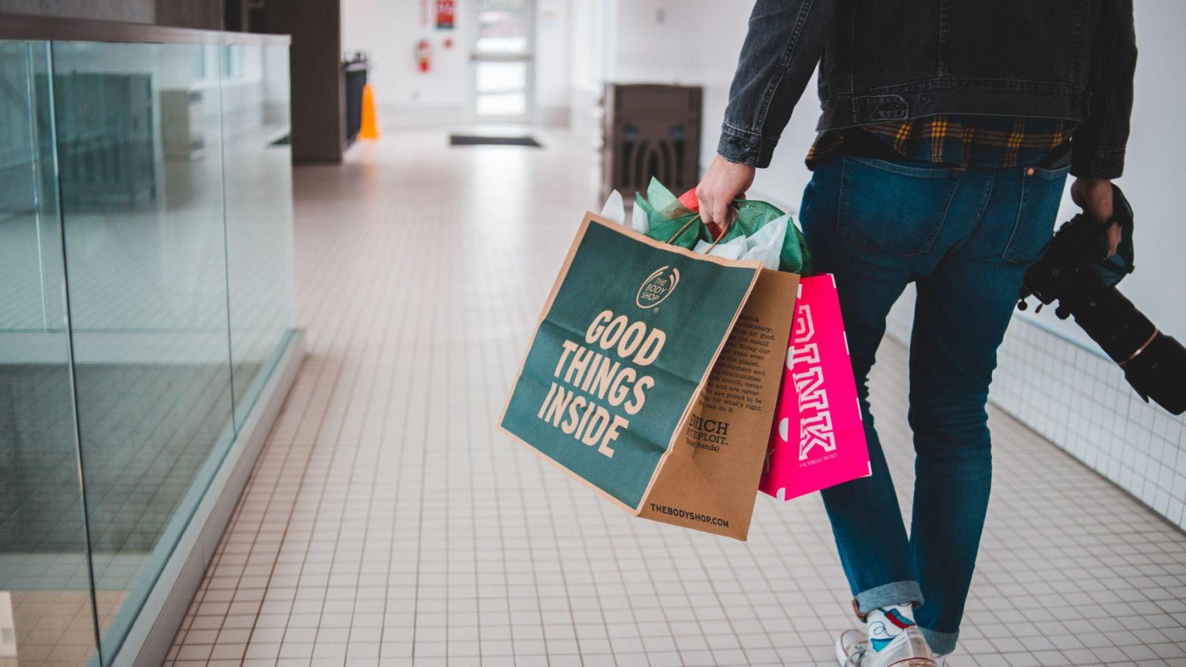Imagen de archivo de una persona con bolsas de compras