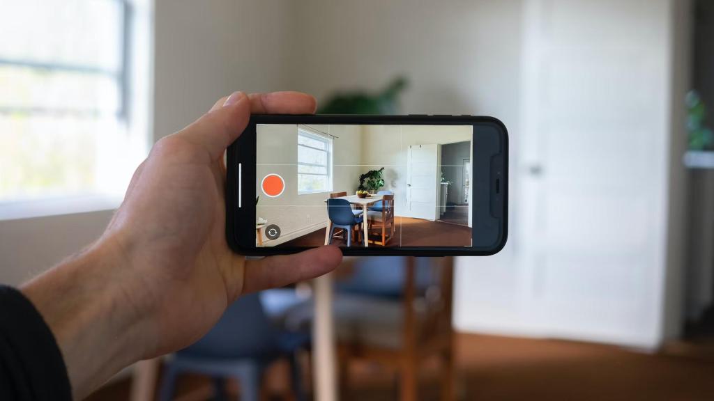 Una persona grava amb el mòbil l'interior d'un habitatge