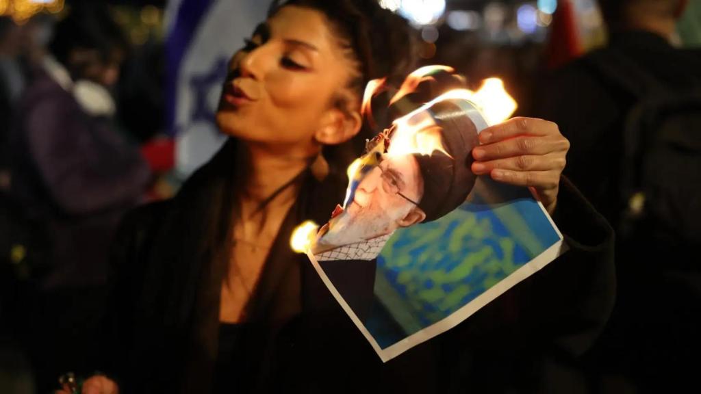 Una manifestant crema una foto d'Alí Jamenei