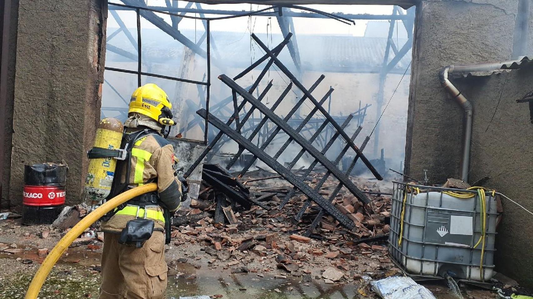 Bomberos apagando el fuego en una nave de Sabadell