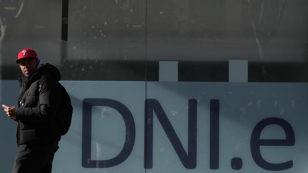 Un policía Nacional atiende a una persona durante la presentación de la prueba piloto de citas previas automatizadas de extranjería de L’Hospitalet (Barcelona).