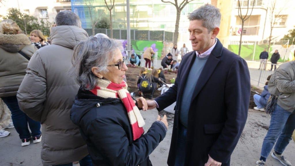 El alcalde de L'Hospitalet, David Quirós, con una vecina durante la plantación
