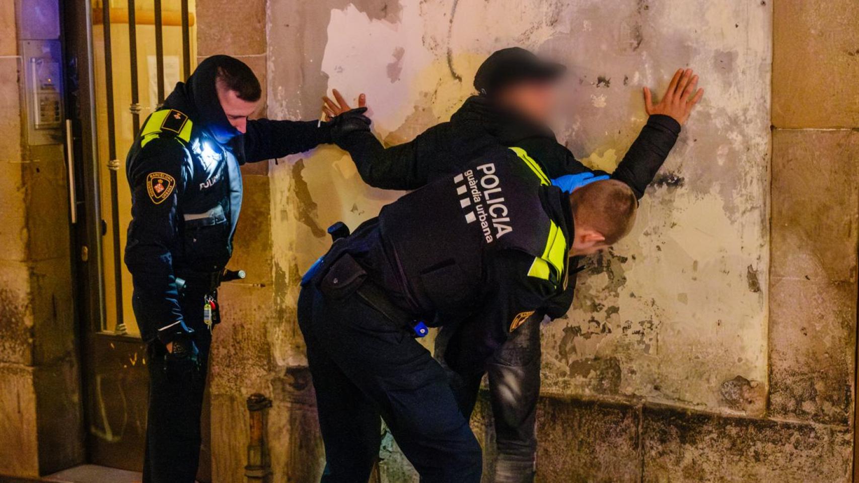Agentes de la Guardia Urbana con un detenido
