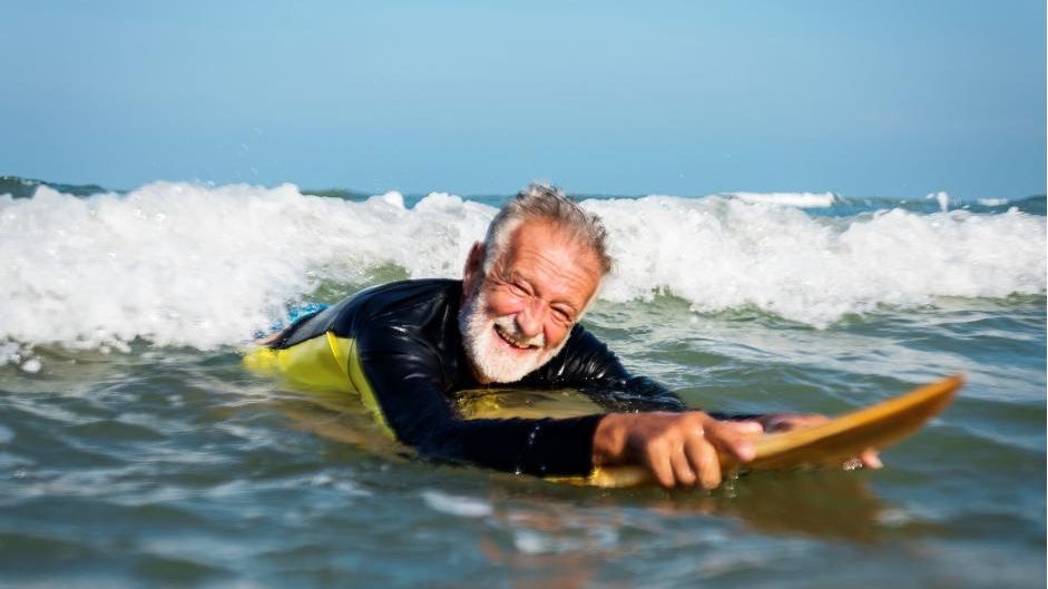 Un hombre mayor practica surf