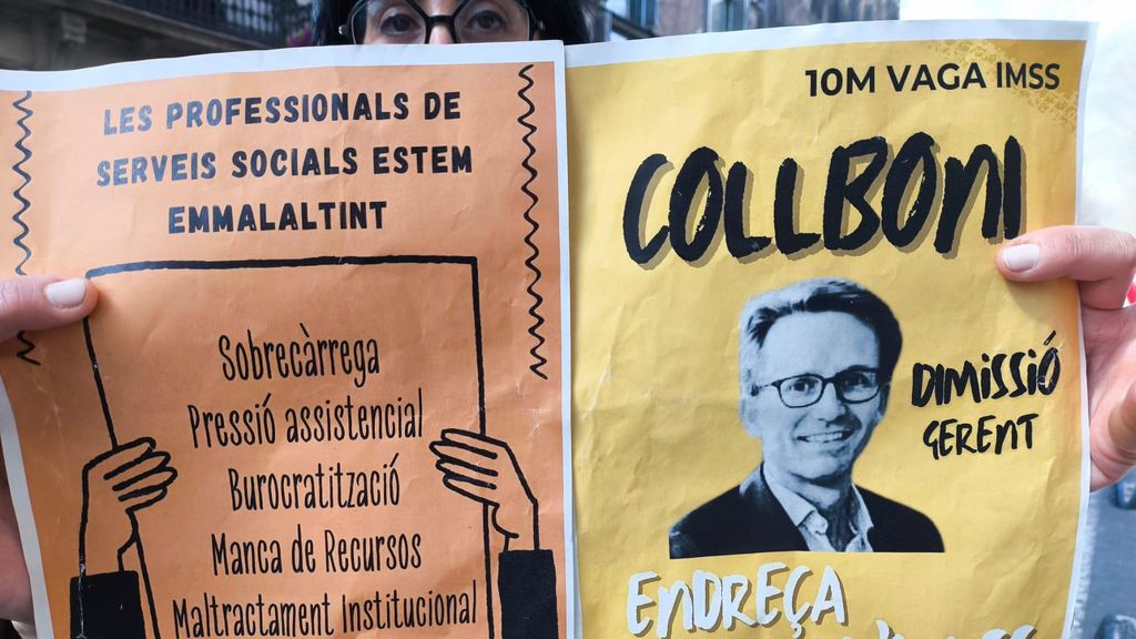 Una manifestant sosté un cartell durant la manifestació dels Serveis Socials de Barcelona