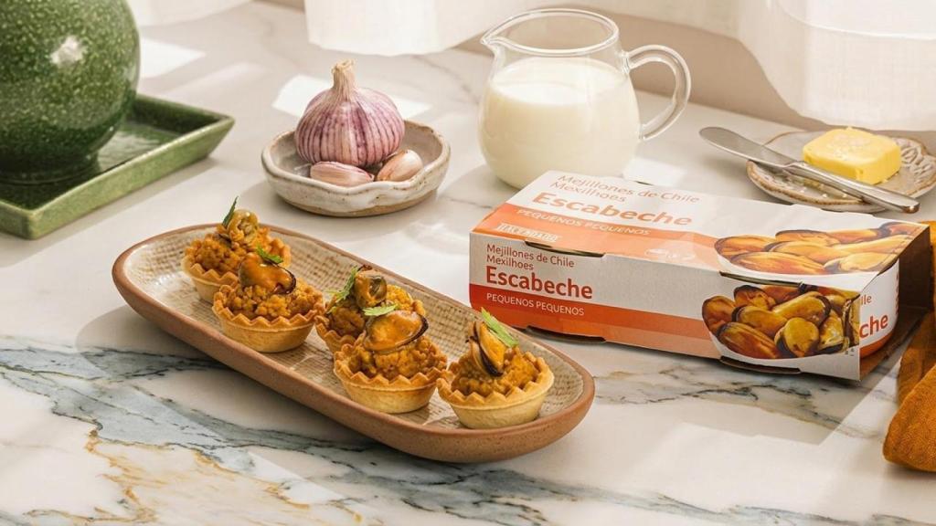 El plato de tartaletas con crema de mejillón con varios de los ingredientes que se necesitan para prepararlos: leche, ajo y mantequilla