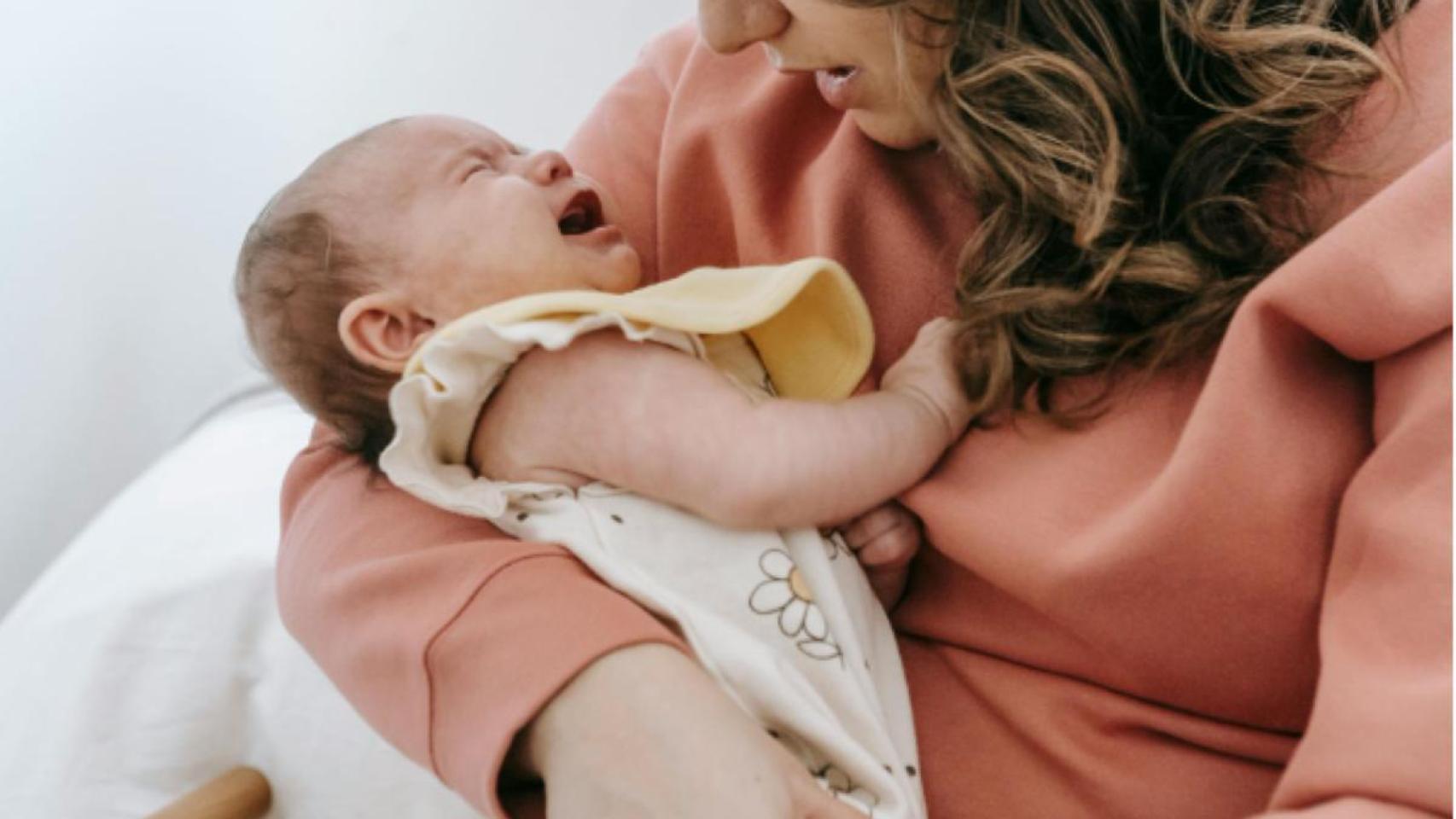 Una madre trata de consolar a su bebé