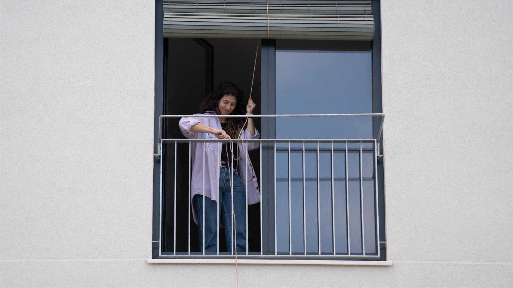 Una inquilina cierra la persiana de su piso en Barcelona