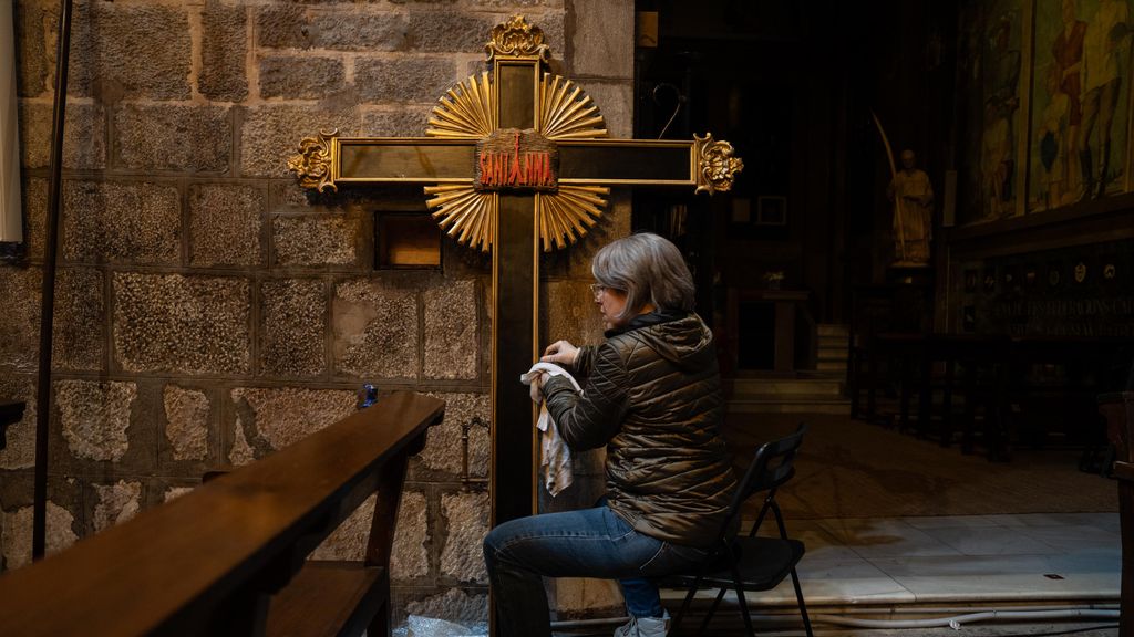 Una voluntària netejant una creu per a la processó del Crist de la Bona Mort a Barcelona