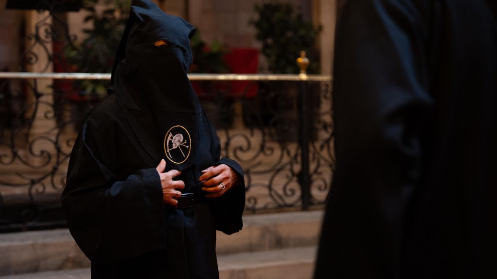 Una persona sense sostre provant-se una túnica per a la processó del Crist de la Bona Mort