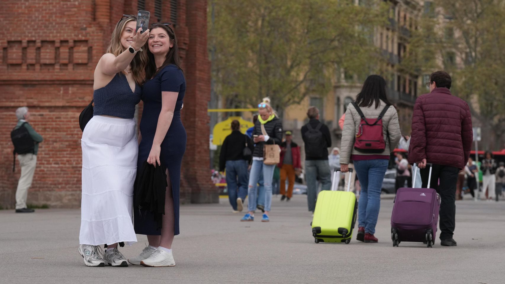 Dos turistas junto al Arc del Trionf de Barcelona haciéndose un selfie