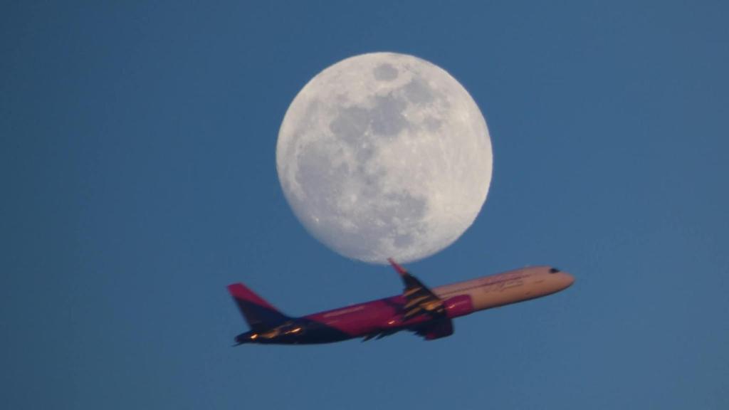 Un avión sobre la luna llena desde Gavà