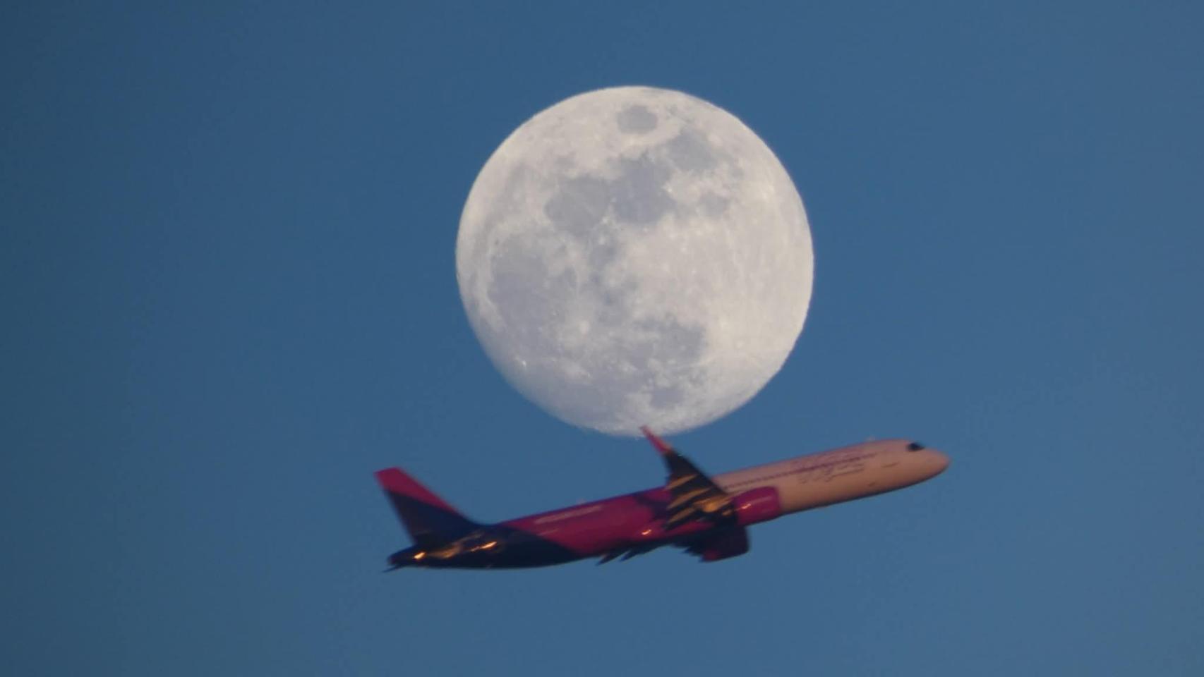 Un avión sobre la luna llena desde Gavà