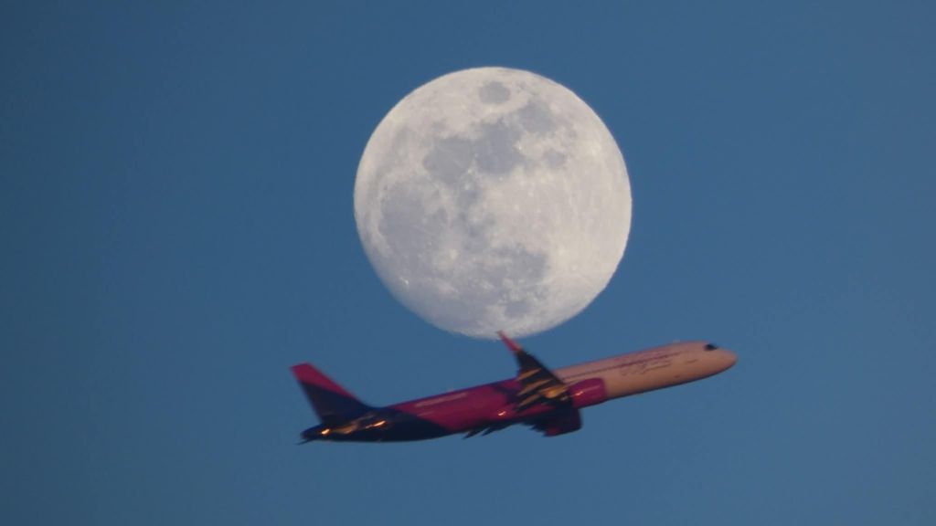 Un avión sobre la luna llena desde Gavà