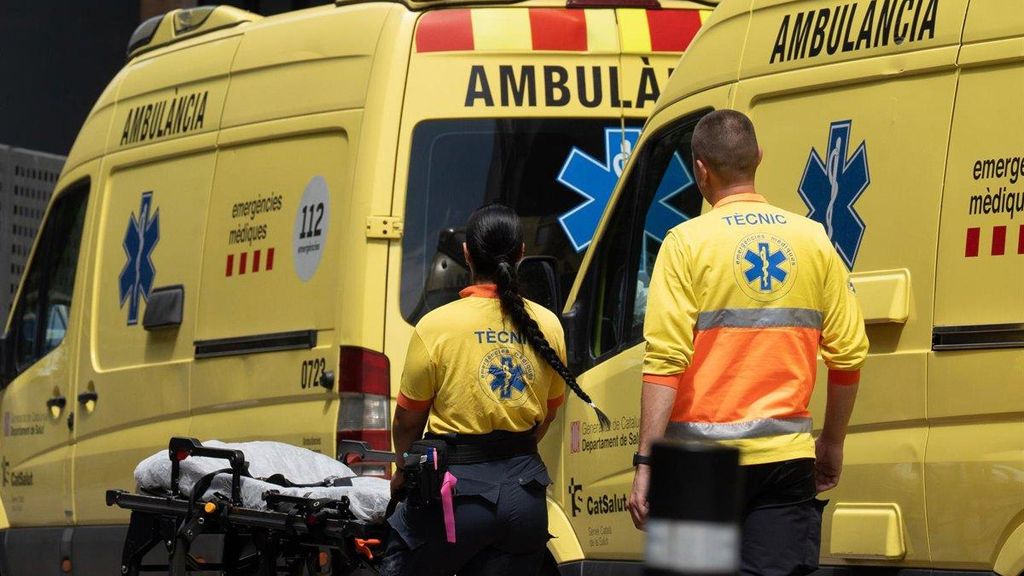 Dos profesionales del SEM junto a unas ambulancias