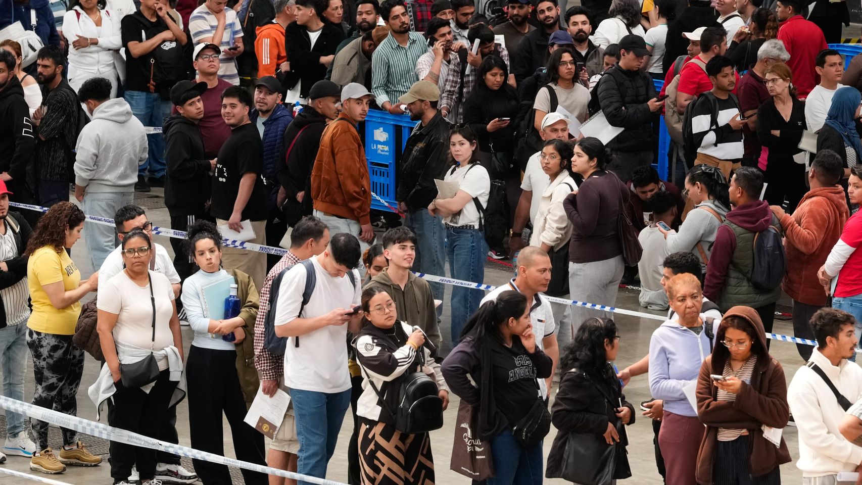 Largas colas en el recinto ferial de La Farga de L'Hospitalet de Llogrega, donde han acudido este lunes para solicitar de forma presencial la regularización extraordinaria de migrantes