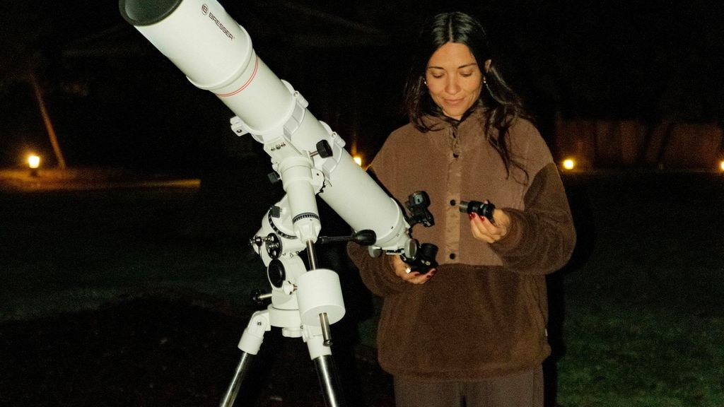 Una noia al costat d'un telescopi per veure un eclipsi