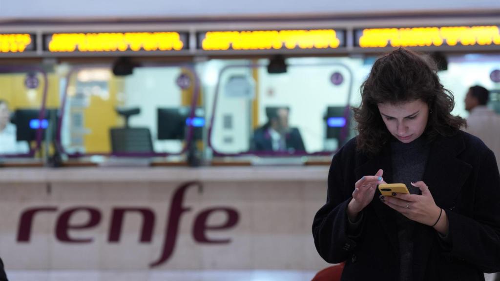 Una persona espera en la Estación de Sants ante una ventanilla de Renfe