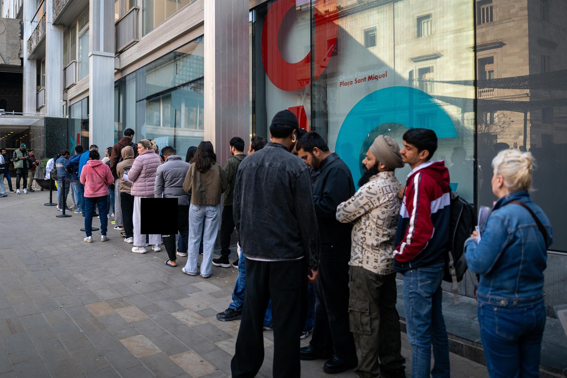 Varias personas hacen cola en una oficina de atención al ciudadano, a 20 de abril de 2026, en Barcelona