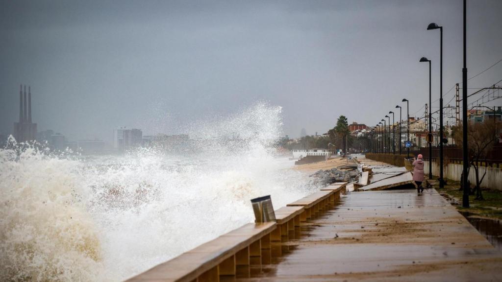 Una persona pasea en el paseo marítimo de playa Barca María afectado por el temporal marítimo en la playa de Barca María