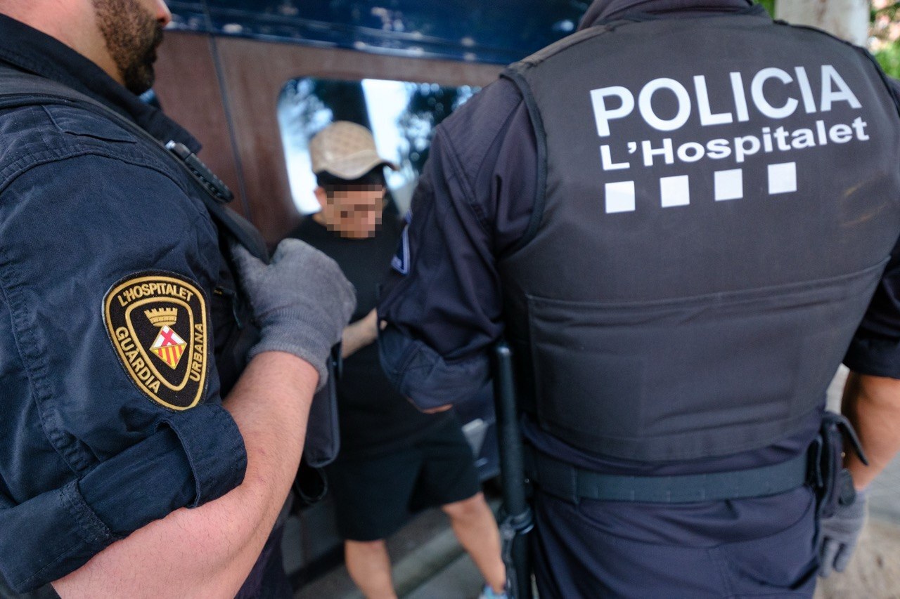 Agentes de la Guardia Urbana de L'Hospitalet con un detenido