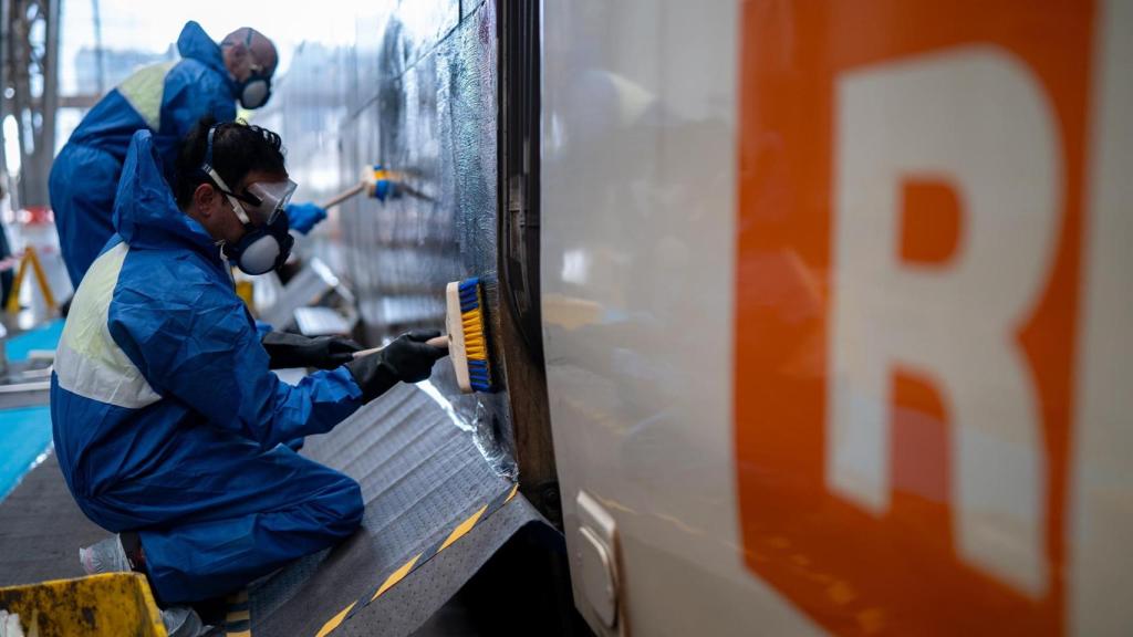 Operaris netegen grafits a vagons de tren a l'Estació de França de Barcelona
