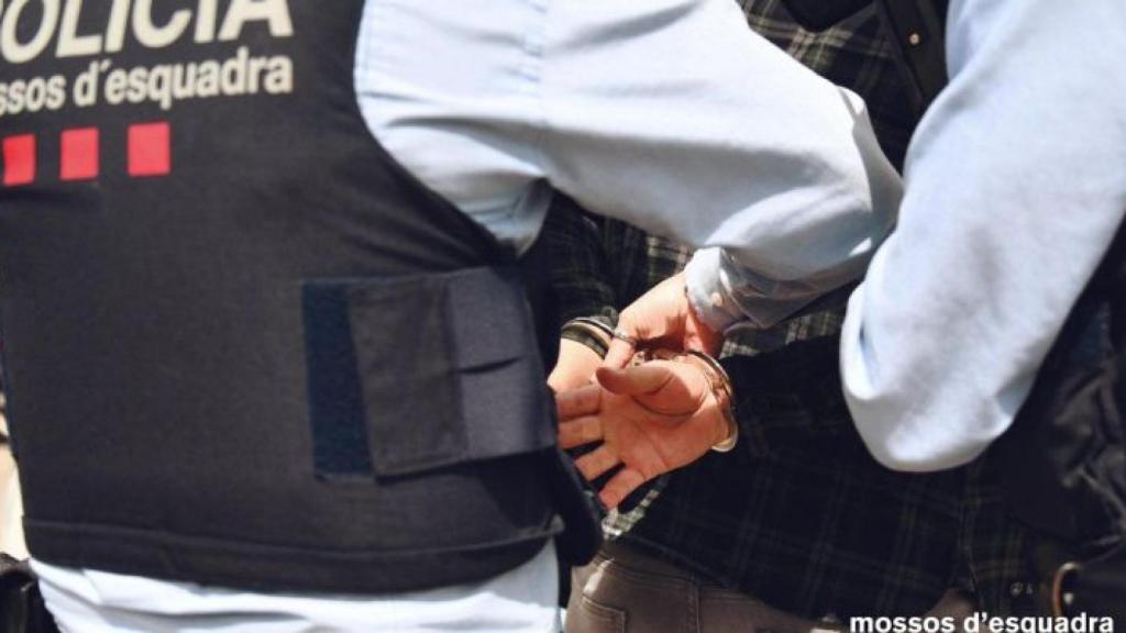 Un agente de los Mossos d'Esquadra con un detenido en una imagen de archivo