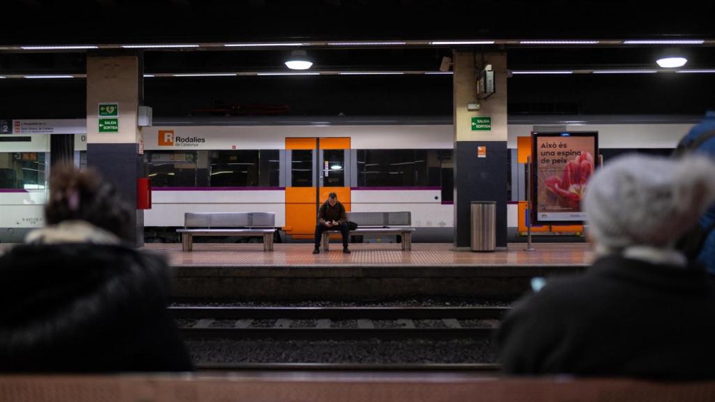 Diverses persones esperen per agafar un tren a l'Estació de Fabra i Puig
