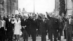 L'alcalde de Barcelona, Enric Masó, el president de la Diputació, Juan Antonio Samaranch, i el ministre de l'Interior, Rodolfo Martín Villa, celebren el 18 de juliol de 1974 a les Drassanes. Masó no fa la salutació feixista.