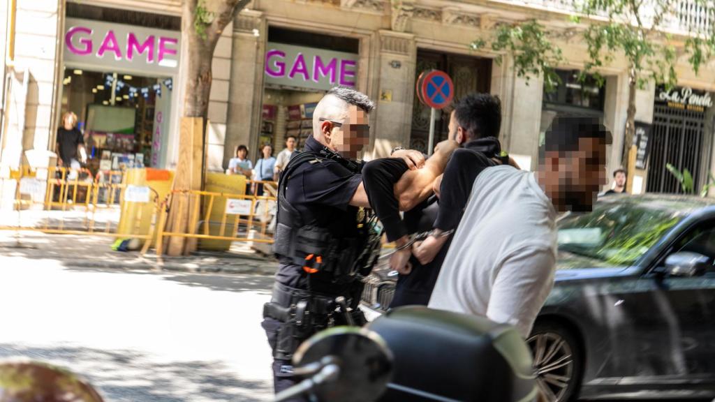 Momento de la reducción y detención del 'rider' de Glovo en pleno centro de Barcelona, este lunes